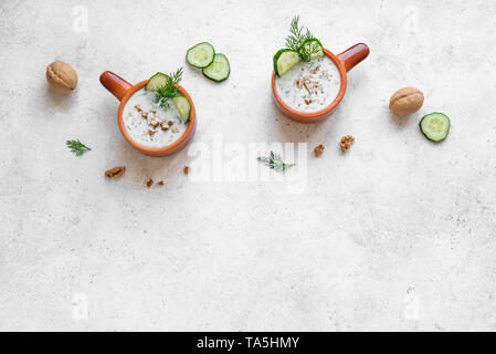 Tarator - Bulgarische Küche. Sommer kalte Suppe mit Joghurt, Kräuter, Walnüsse und Gurke für gesunde Ernährung, Ansicht von oben, kopieren. Stockfoto