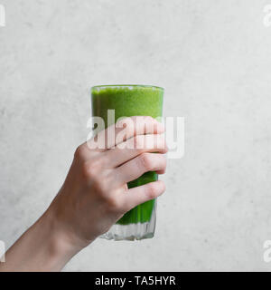 Grüne Smoothie in der Hand. Weibliche hand Glas grüne Spinat Detox-smoothie, kopieren. Stockfoto
