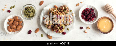 Energie beißt mit Nüssen, Samen, chemische Preiselbeeren und Honig - vegan vegetarisch organischen snack Müsli Bissen auf weißem Hintergrund, Banner. Stockfoto