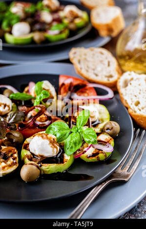 Close-up Ciabatta, Italienischer Salat mit gegrilltem Gemüse, Basilikum und Balsamico Soße auf Rost Hintergrund. Mediterrane Küche. Close-up Stockfoto