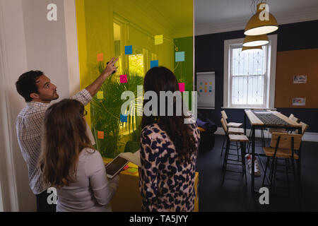 Geschäft Leute diskutieren über Haftnotizen auf Glas Wand im Büro Stockfoto