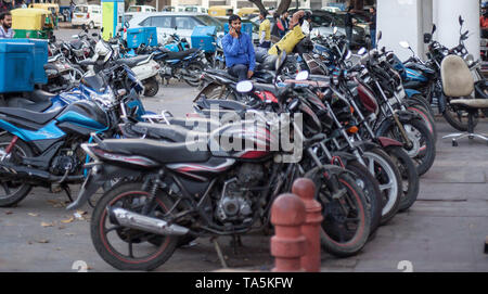 Am 22. März 2019 telefoniert ein Mann auf dem Parkplatz für Motorräder in Connaught Pace in Neu-Delhi, Indien. Connaught Place wird oft nur genannt Stockfoto