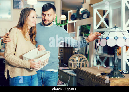 Junges Paar Auswahl Tischleuchte für Wohnung in Möbeln store Stockfoto