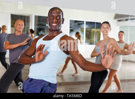 Fröhliche freundliche Menschen üben heftige Lindy Hop Bewegungen im Tanz Klasse Stockfoto