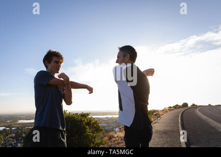 Vater und Sohn zu tun stretching Übung auf der Straße Stockfoto