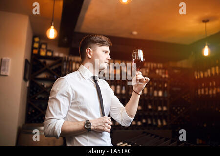 Stattlicher Mann mit Glas und Schauen durch. Schließen Seitenansicht Foto. Stockfoto
