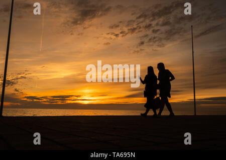 Aberystwyth Wales UK, Mittwoch, 22. Mai 2019 Deutschland Wetter: Zwei Frauen Silhouette schlendern entlang der Strandpromenade bei Sonnenuntergang in Aberystwyth an einem milden kann Abends, am Ende eines Tages der warmen Frühlingssonne an der Westküste von Wales. Photo Credit: Keith Morris/Alamy leben Nachrichten Stockfoto