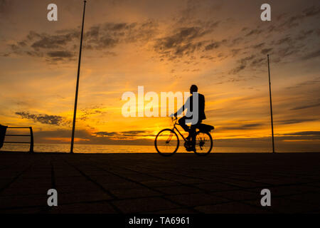 Aberystwyth Wales UK, Mittwoch, 22. Mai 2019 Deutschland Wetter: Menschen silhouetted Radfahren entlang der Strandpromenade bei Sonnenuntergang in Aberystwyth an einem milden kann Abends, am Ende eines Tages der warmen Frühlingssonne an der Westküste von Wales. Photo Credit: Keith Morris/Alamy leben Nachrichten Stockfoto