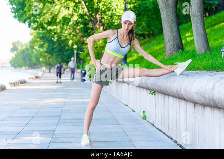 Portrait von schlanke Frau Athlet, Aufwärmen vor dem Joggen im Park ist eine Stadt Stockfoto