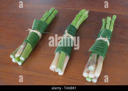 Spargel umwickelt in Banana auf einem Holztisch Blatt. Dies ist eine hervorragende Lösung, wie Verpackungen aus Kunststoff ersetzen und die Taille - Bali, Ind reduzieren Stockfoto