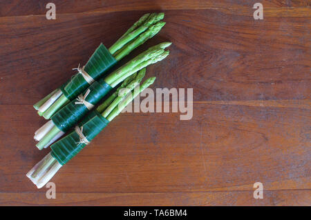 Spargel umwickelt in Banana auf einem Holztisch Blatt. Dies ist eine hervorragende Lösung, wie Verpackungen aus Kunststoff ersetzen und die Taille - Bali, Ind reduzieren Stockfoto