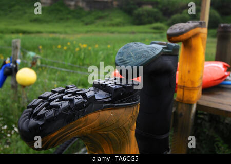 Isle of Skye, Schottland - 11 Juni 2014: Blick auf einige wellies auf einigen Holzpfähle während eines regnerischen Tag platziert Stockfoto