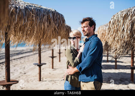 Ein junges Paar steht im Freien auf Strand, umarmen. Kopieren Sie Platz. Stockfoto