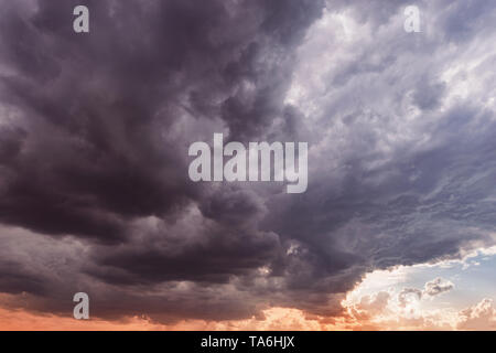 Dunkle Gewitterwolken vor Regen bei Sonnenuntergang. Stockfoto