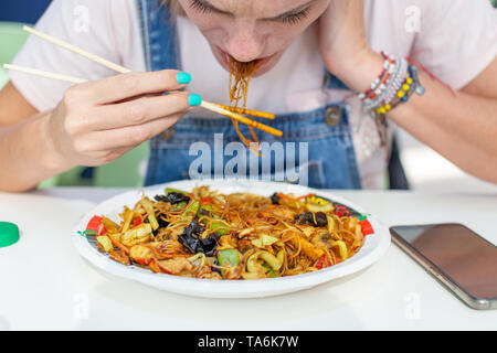 Junge Frau hasst chinesische Nudeln essen im Restaurant Stockfoto