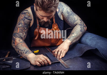 Leder Arbeiter scharf auf das Geschäft an seinem Leder studio Stockfoto