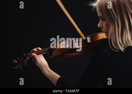 Junge konzentrierte sich Frau Cello spielen mit Bug isoliert auf Schwarz mit Kopie Raum Stockfoto