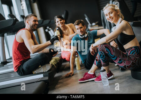 Gruppe von jungen Menschen in Sportswear sprechen in einer Turnhalle nach dem Training Stockfoto