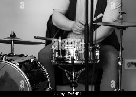 Schwarze und weiße live Musik Hintergrund, Schlagzeuger spielt mit Trommelstöcken ein Drum Set. Closeup Foto mit weichen selektiven Fokus Stockfoto