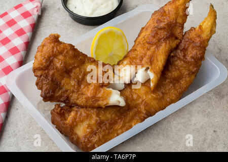 Frittierter Fisch Filet, genannt lekcurbek in Niederländisch, serviert in einer Plastikschale mit Sauce und Zitrone Nahaufnahme Stockfoto