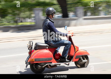 Belgrad, Serbien - Mai 20, 2019: Ein grosser Mann auf einer kleinen Oldtimer Roller sppeding auf der Stadt. Stockfoto