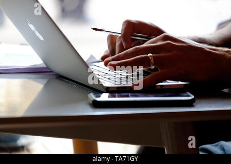 Person mittels Laptop auf Cafe table top, Norfolk, England Stockfoto