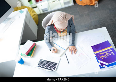 Blick von oben auf die Englisch Lehrerin hijab am Tisch arbeiten Stockfoto