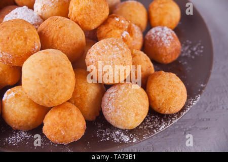 Schließen Sie die Platte mit kleinen Kugeln von frisch gebackenem hausgemachten Quark Krapfen Stockfoto