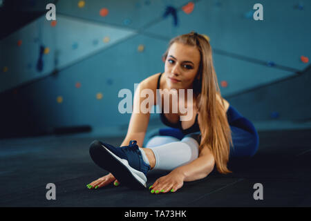 Stretching gymnast Mädchen tun Erwärmung grossmanoever. Blick auf die attraktive junge Frau Sport bei crossfit Fitnessraum Stockfoto