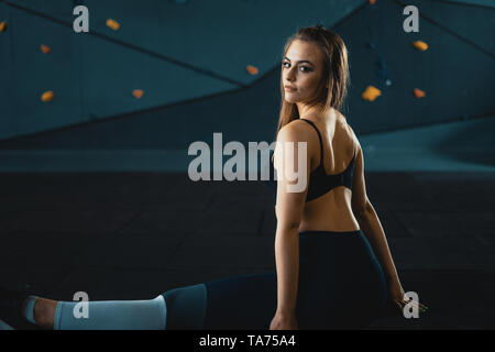 Stretching gymnast Mädchen tun Vertical Split, Garn. Seitenansicht der attraktive junge Frau tun core Übung bei crossfit Fitnessraum Stockfoto