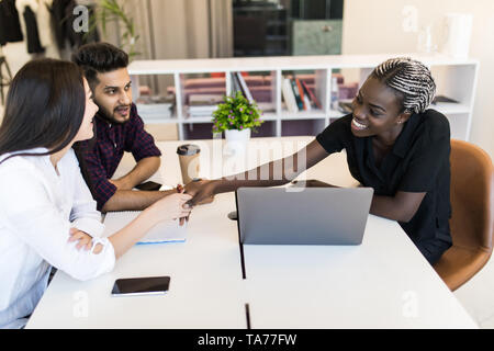 Junge Führungskraft ihre Ideen Präsentation vor Kollegen in einem Meeting. Jungen gemischten rennen Leute diskutieren Arbeit am Schreibtisch im Büro. Stockfoto