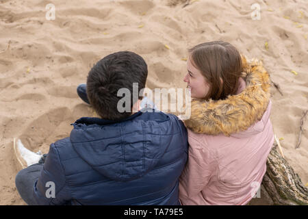 Ein verliebtes Paar sitzt im Sand Stockfoto