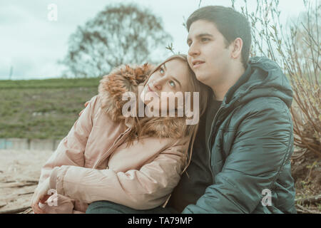 Ein junges Paar glücklich zusammen sitzen in der Natur Stockfoto