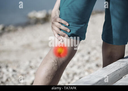 Frau berühren schmerzhafte Krampfadern auf einem Bein mit red dot Effekt. Healthcare Konzept. Stockfoto