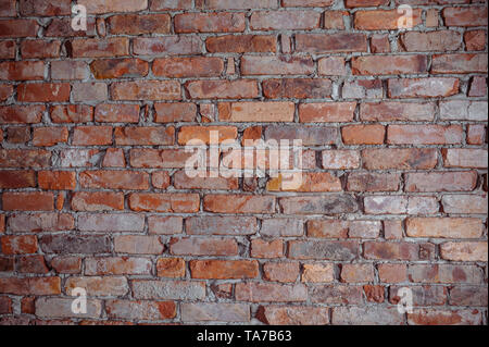 Wand mit braunen Ziegelsteinen gemischt zufällig mit kleinen schwarzen. Hintergrund und Textur mit Kopierraum Stockfoto