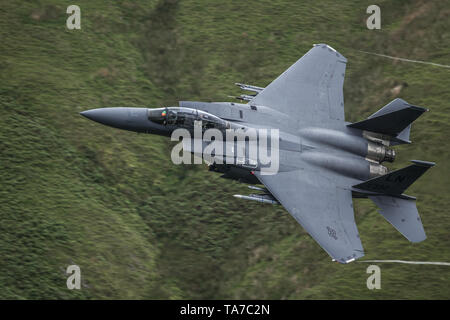 USAF F-15 E Strike Eagle flying low level durch das Mach Loop in Wales, Großbritannien Stockfoto