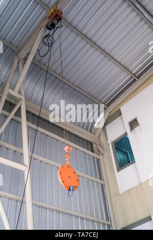 Kleine Seil Schlinge der elektrischen Kran hängt auf dem Dach der Fabrik. Stockfoto