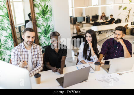 Gruppe von Menschen, die Diskussion von Plänen, mit Laptops, Pläne im Büro Stockfoto