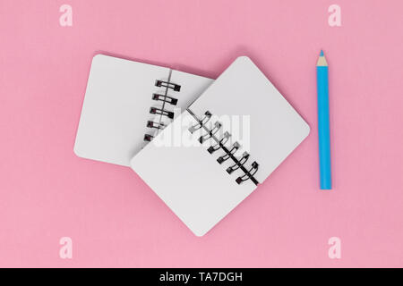 Notebooks und Bleistift auf einem rosa Hintergrund öffnen Stockfoto