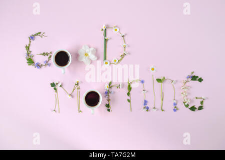 'Guten Morgen' aus Blumen und zwei Kaffee Tasse auf rosa Hintergrund. Frühling und Sommer Konzept. Flach, Ansicht von oben, kopieren Raum Stockfoto