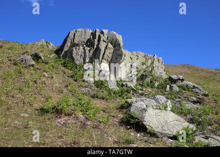 Felsvorsprüngen auf der Seite Hallin fielen, ein englischen Lake District fellside, Cumbria, Vereinigtes Königreich gegen den blauen Himmel an einem sonnigen Frühlingstag gesehen. Stockfoto