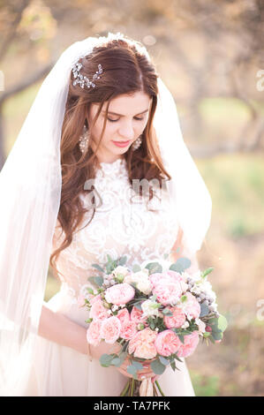 Schöne Braut Mädchen mit Blumen im Freien. Hochzeitstag. 20. Stockfoto