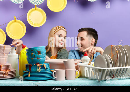 Junges Paar poiting an ungewaschene tablewear in der Küche. bossy gerissen Frau fragt ihr Mann das Geschirr spülen Stockfoto