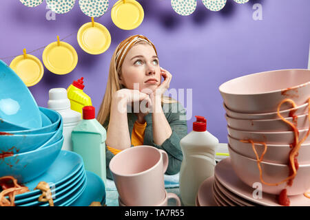 Ernsthafte schönen blonden Hausmädchen sieht nachdenklich, legere Kleidung, Hygiene Konzept Stockfoto