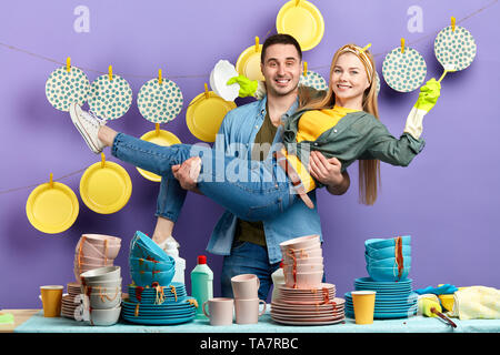 Schön lächelnden Mann seine Freundin in den Armen halten und schauen in die Kamera. nach oben Foto schliessen. verliebtes Paar Stockfoto