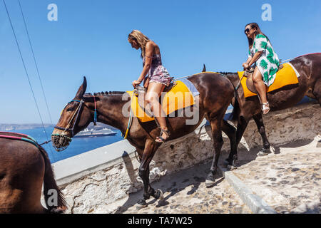 Santorini Eselspfad, zwei Frauen reiten hinunter zum Hafen, griechische Inseln Santorini Touristen Griechenland Europa Stockfoto