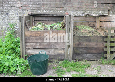 Großer Garten Kompost Struktur des Holzes gegen eine Mauer, Recycling von Abfällen Pflanzen und Lebensmitteln Stockfoto