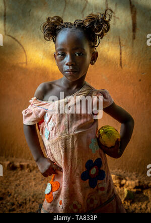 Cute afrikanische Mädchen mit einem Kakao Obst pod in ihren Händen, Savanes Bezirk, Yamoussoukro, Elfenbeinküste Stockfoto