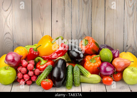 Stapel Obst und Gemüse auf Holztisch auf Hintergrund Holzwand. Platz kopieren Stockfoto