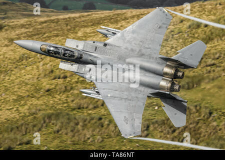 USAF F-15 E Strike Eagle flying low level durch das Mach Loop in Wales, Großbritannien Stockfoto